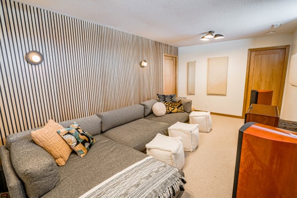 Cozy living room with gray sectional sofa, decorative pillows, and a textured wall.