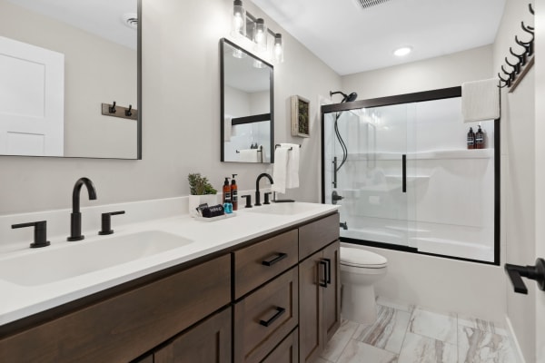 Modern bathroom featuring a white countertop, dark wood cabinets, and a glass shower enclosure.