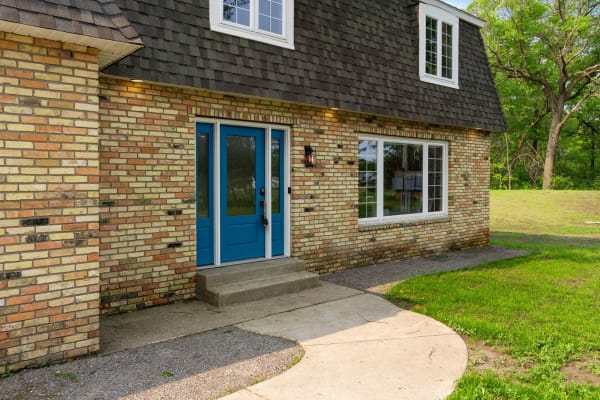 Exterior view of a house featuring blue double doors and a brick facade.
