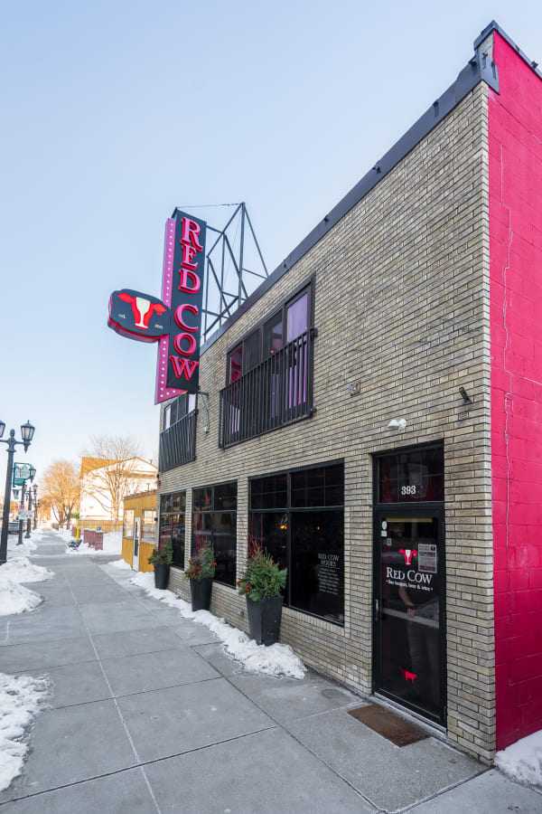 Exterior view of Red Cow restaurant with vibrant signage and snowy sidewalk.