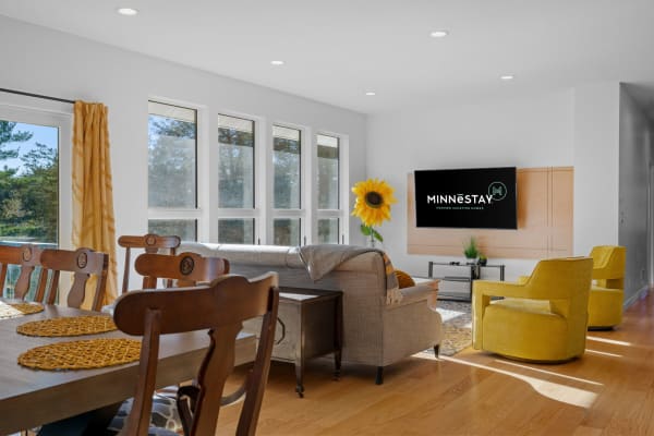 Bright living room featuring a gray sofa, yellow armchairs, and a sunflower.