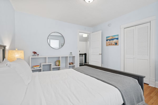 Cozy bedroom with a wooden bed, light blue walls, and decorative elements.