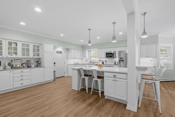 Modern kitchen featuring white cabinetry and an island with stools.