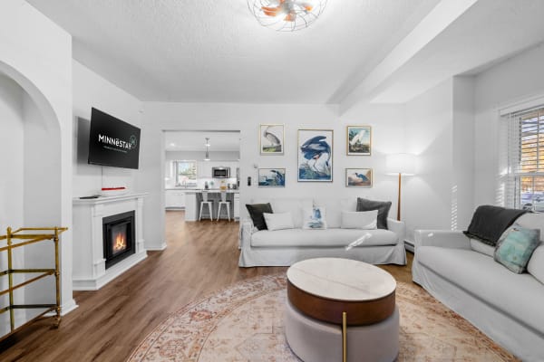 Bright living room with white walls, a fireplace, and modern furnishings.