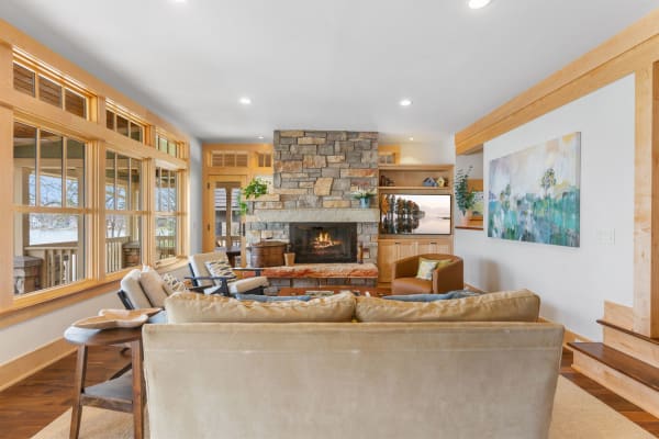Warm and inviting living room featuring a stone fireplace and wooden accents.