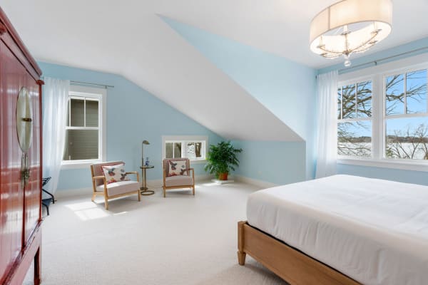 Serene bedroom with a blue wall, white carpet, and stylish furniture.