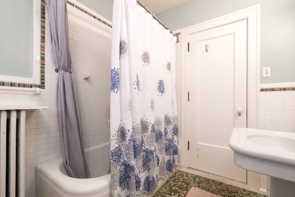 Cozy bathroom with a gray shower curtain and tiled walls
