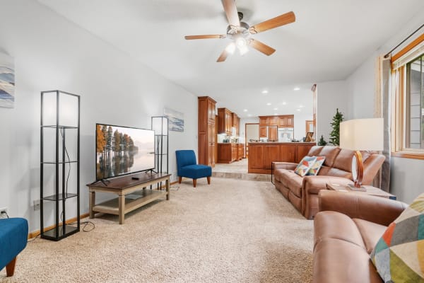 Modern living room with a large TV, brown leather sofas, and contemporary furniture.