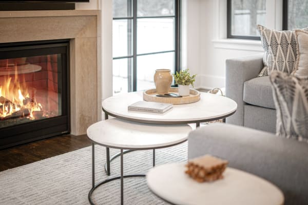 Living room featuring coffee tables, a fireplace, and a grey sofa.