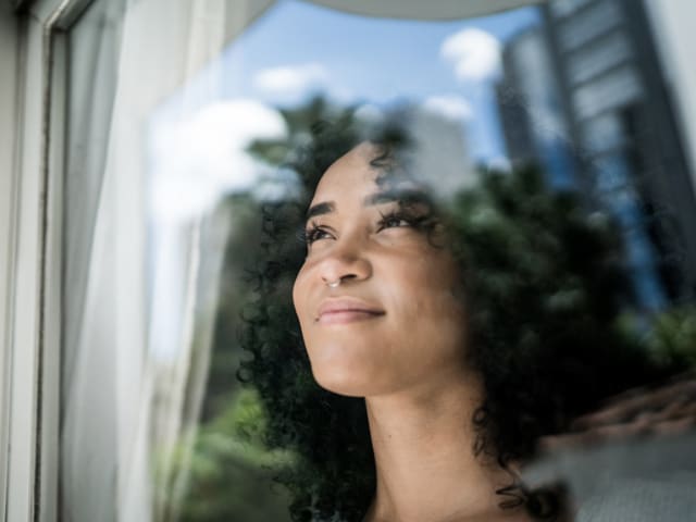 A teen looking out a window in quiet thought