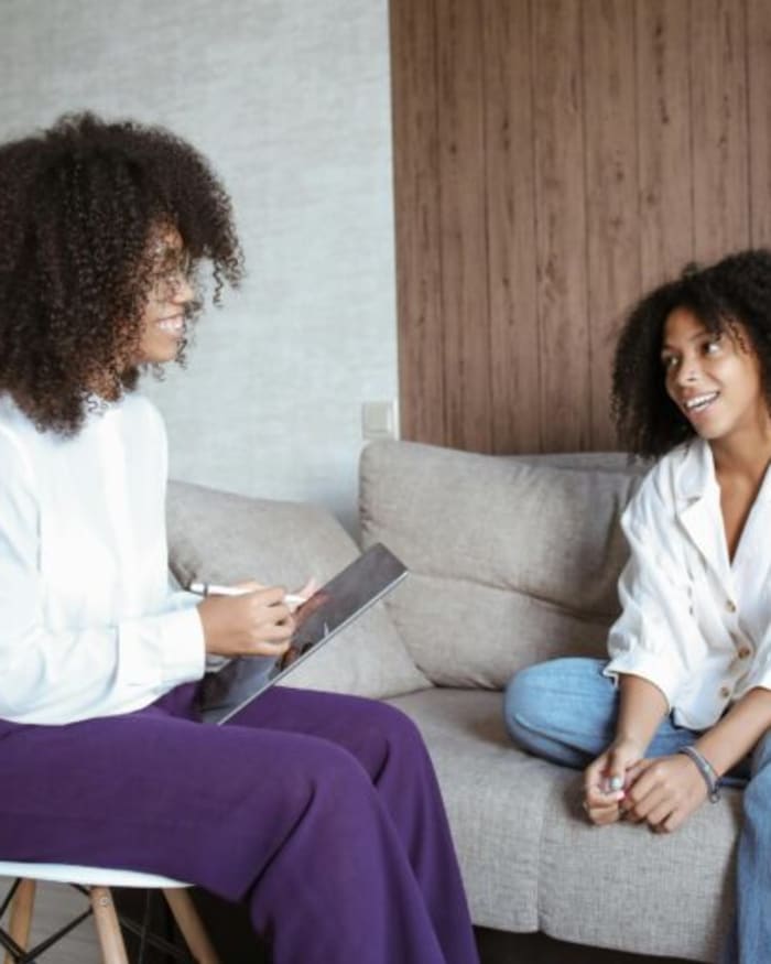 Two women in a warm conversation on a couch