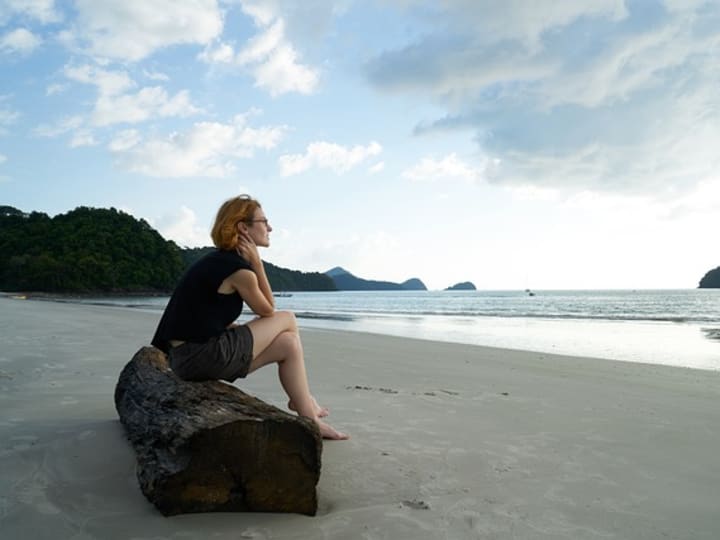 A person standing quietly on a beach