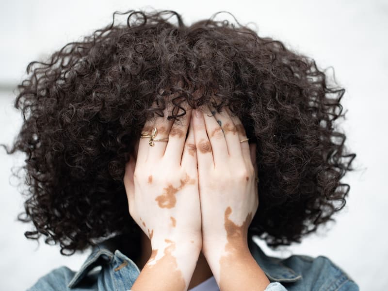 A woman with curly hair in a quiet, reflective moment