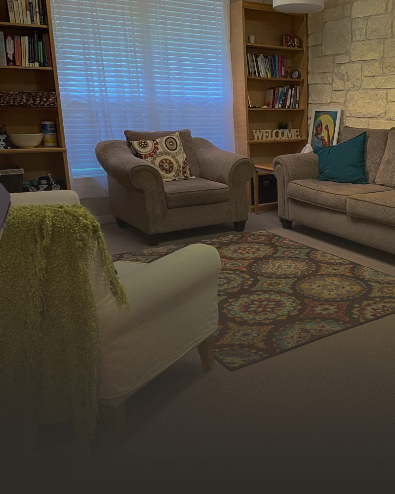 A cozy therapy room at the Austin office with armchairs and a stone wall