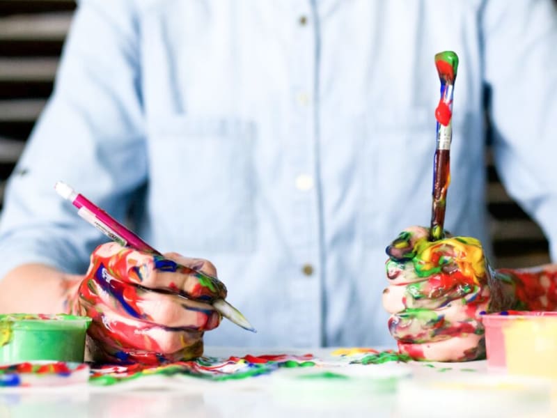 Hands covered in colorful paint