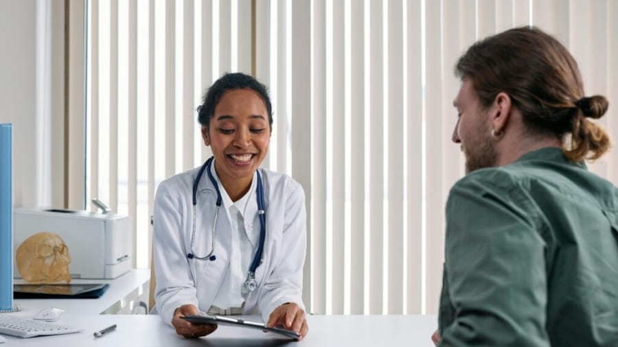 A doctor speaking with a patient in a warm medical setting