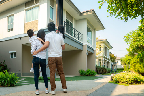 Husband and wife outside their new house