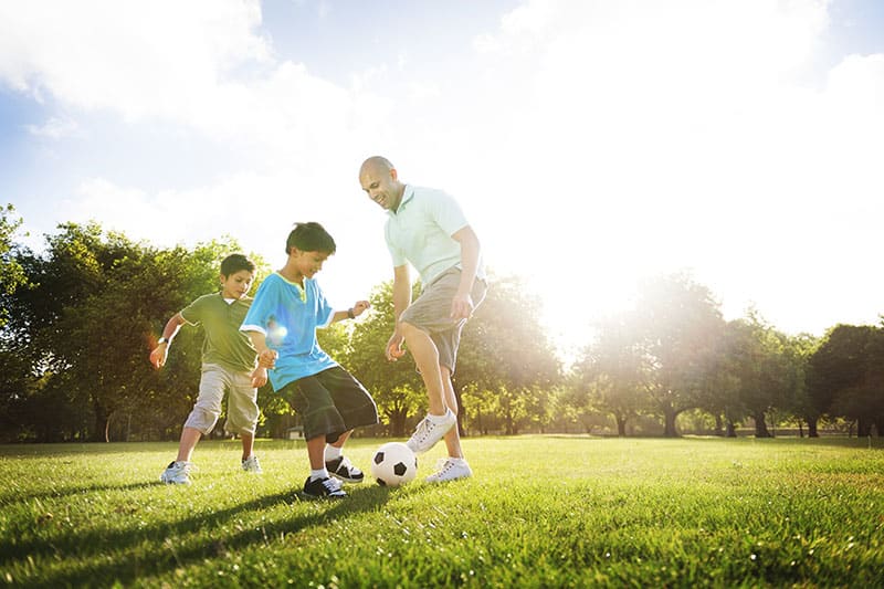 Child and adult playing soccer