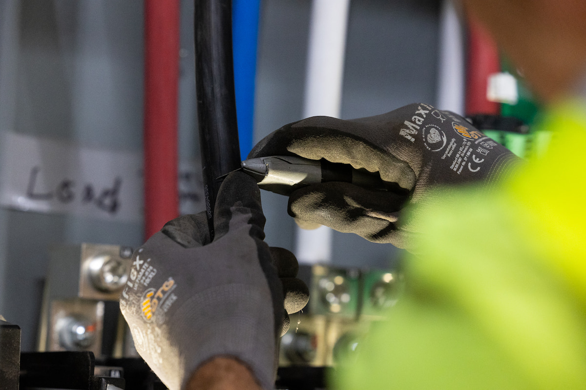 hands cutting rubber tube with knife