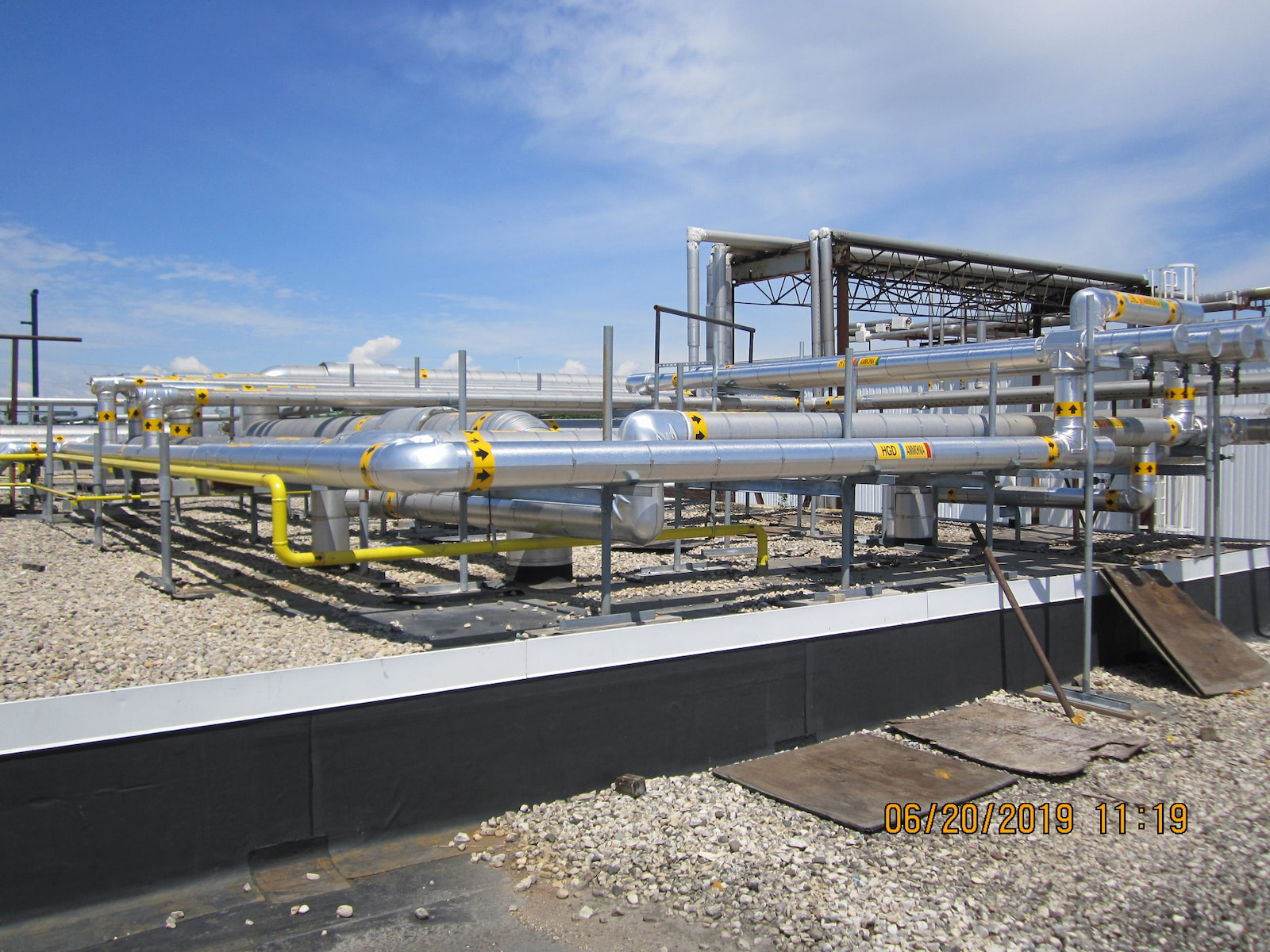 Ammonia refrigeration piping system installed on a commercial rooftop with labeled insulated lines