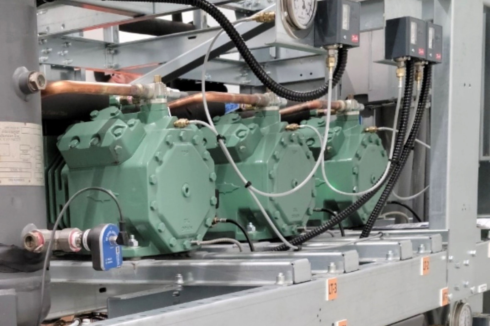Row of CO2 refrigeration compressors used in commercial and industrial cooling systems