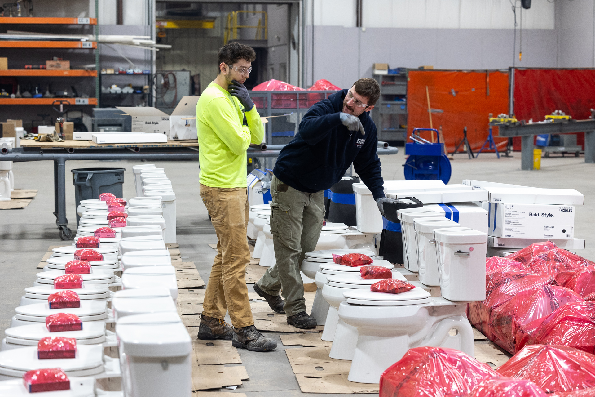 HMI technicians preparing Kohler toilets for commercial plumbing installation in Green Bay, WI.