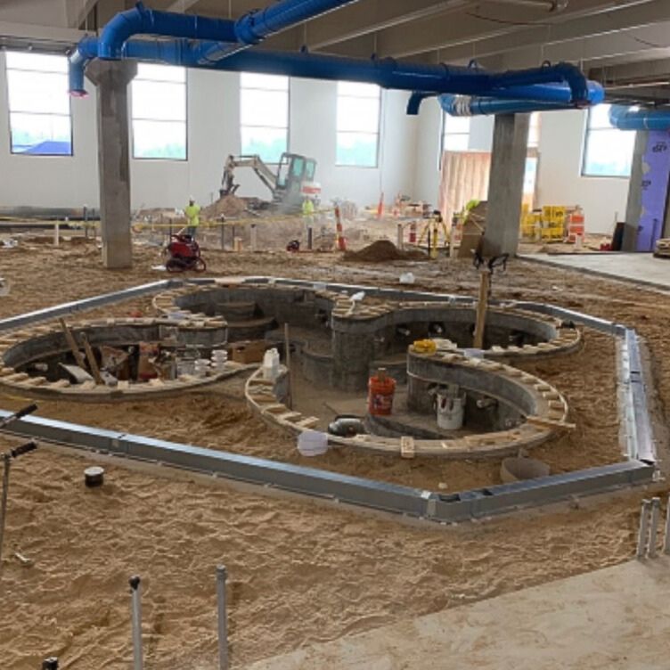 pool trench drains during commercial plumbing construction build of island resort and casino water park