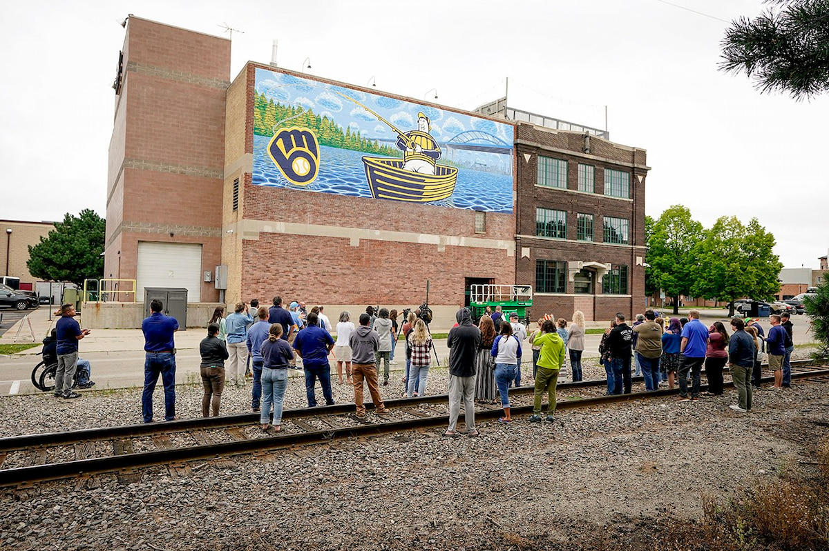 Hurckman Mechanical team, Milwaukee Brewers representatives, and community members attending the mural unveiling at the Hurckman Mechanical headquarters in Green Bay, Wisconsin.