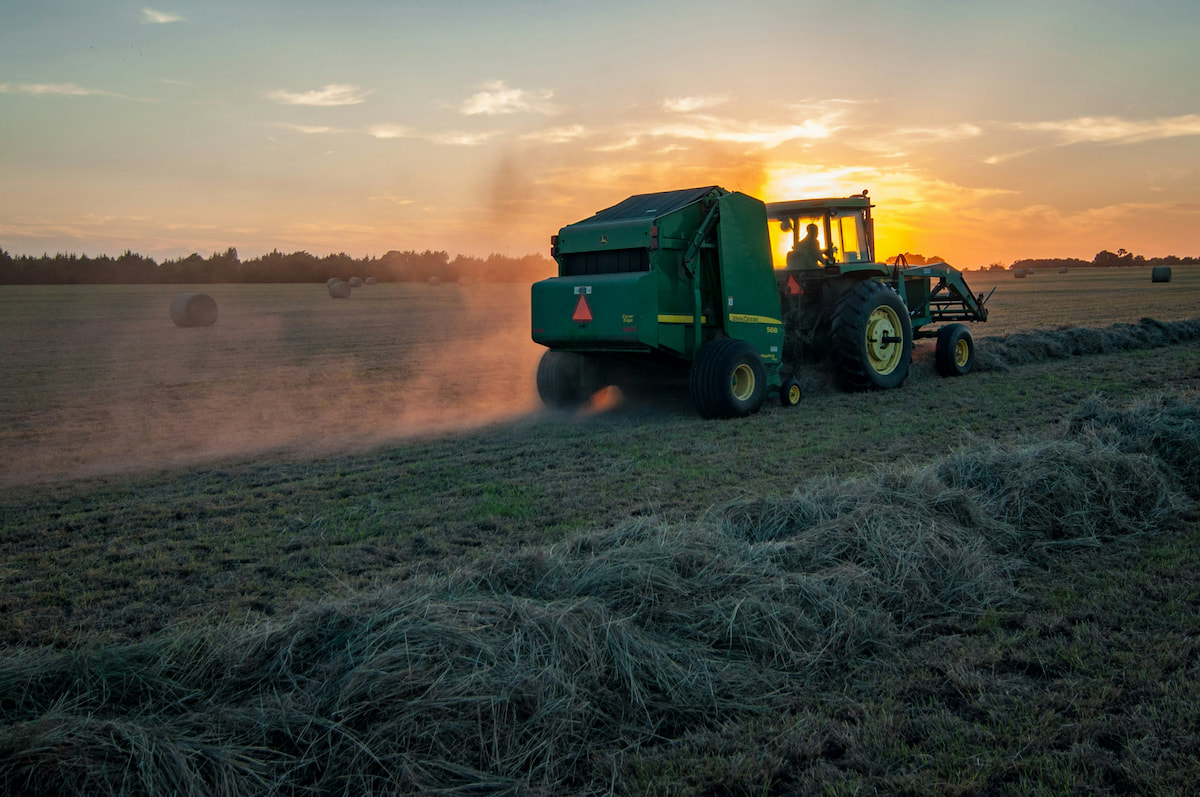 Tractor in a field while baling hay