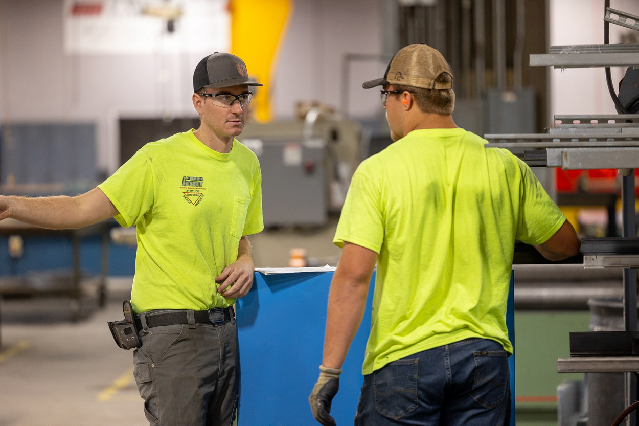 Two employees discussing inspection requirements