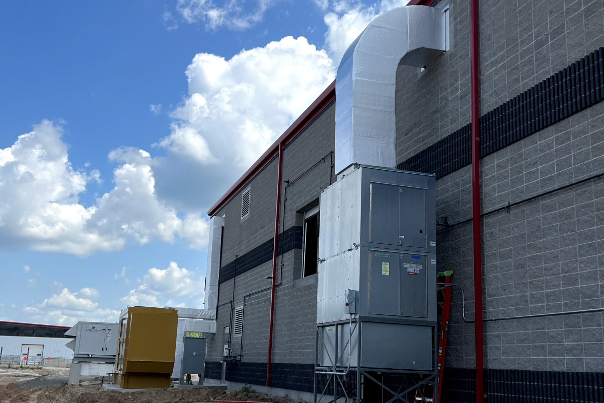 Exterior HVAC unit installation with ductwork at Zahn Farms commercial facility