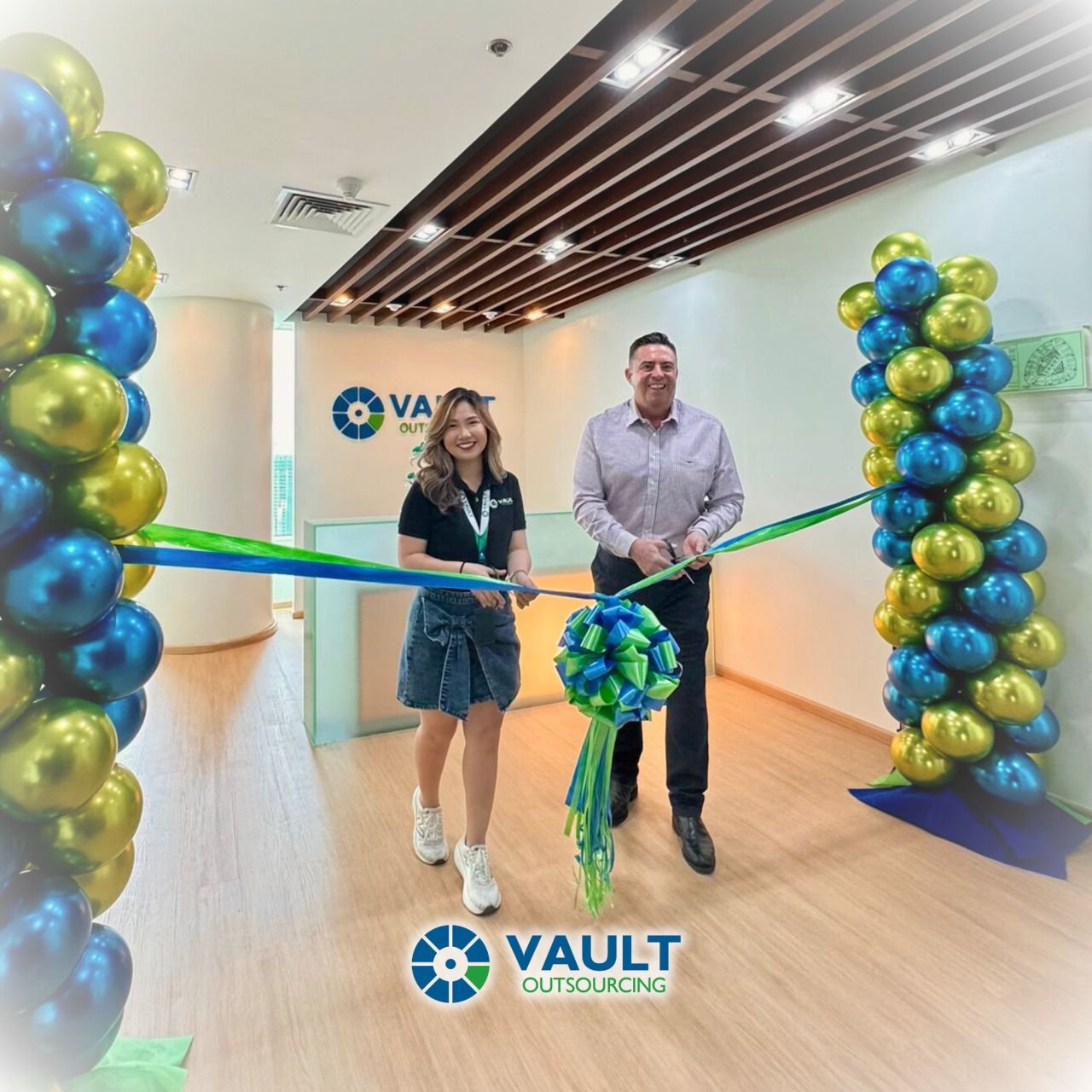 Beryl Fauni and Dean Hutton cutting a ribbon at the entrance of a Vault Outsourcing office