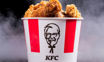 Pot de poulet frit KFC sur fond noir avec vapeur