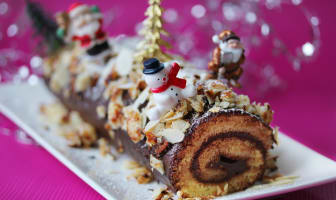 Bûche de noël roulée décorée avec sapins et bonhommes de neige