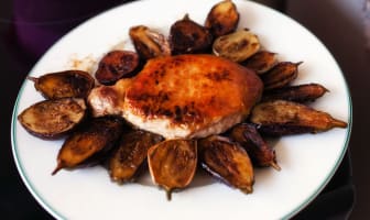 Côte de porc sur assiette entourée de petites aubergines