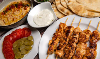 Brochettes de poulet chich taouk, sauce à l'ail, taboulé et houmous