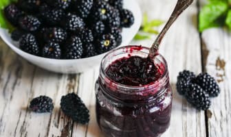 Pot de confiture de mûres et mûres fraîches.