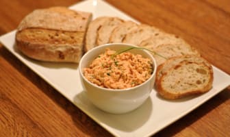 Rillettes de saumon dans un bol avec quelques tranches de pain frais