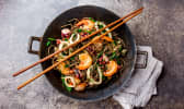 Nouilles sautées aux fruits de mer dans un wok asiatique en fonte