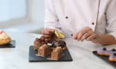 Pâtissier décorant des desserts avec des feuilles d'or comestibles 