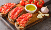 Pain grillé à la tomate et à l'ail sur planche