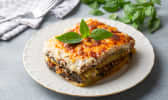 Part de moussaka dans une assiette blanche