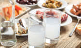 2 verres de ouzo et mezzés sur table en bois