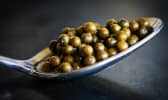Graines de poivre vert dans une cuiller