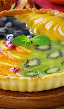 Tarte aux fruits variés sur assiette en bois