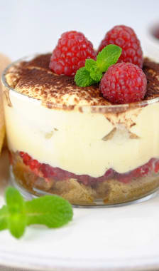 Tiramisu aux framboises en verrine sur assiette blanche