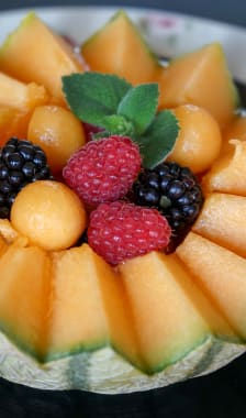 Salade de fruits servie dans un melon découpé en dents de loup