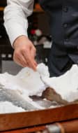 Service d'un poisson cuit en croûte de sel.