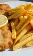 Filet de poisson pané sur assiette blanche avec frites