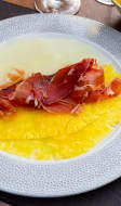 Une assiette de carpaccio d'ananas et de melon avec des fines lamelles de jambon